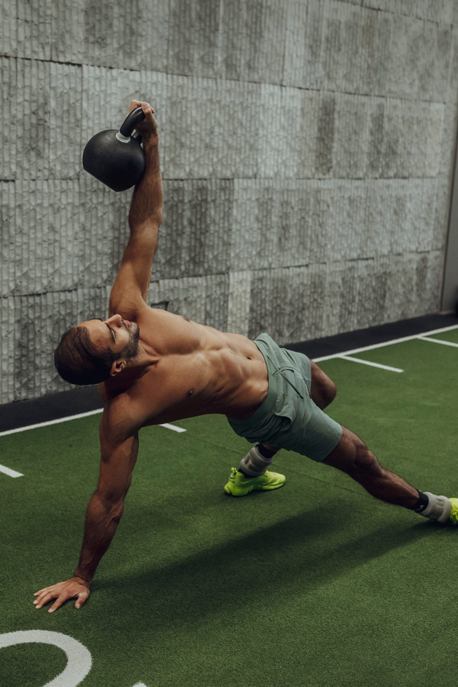 Sultan pressing a kettlebell from a side plank