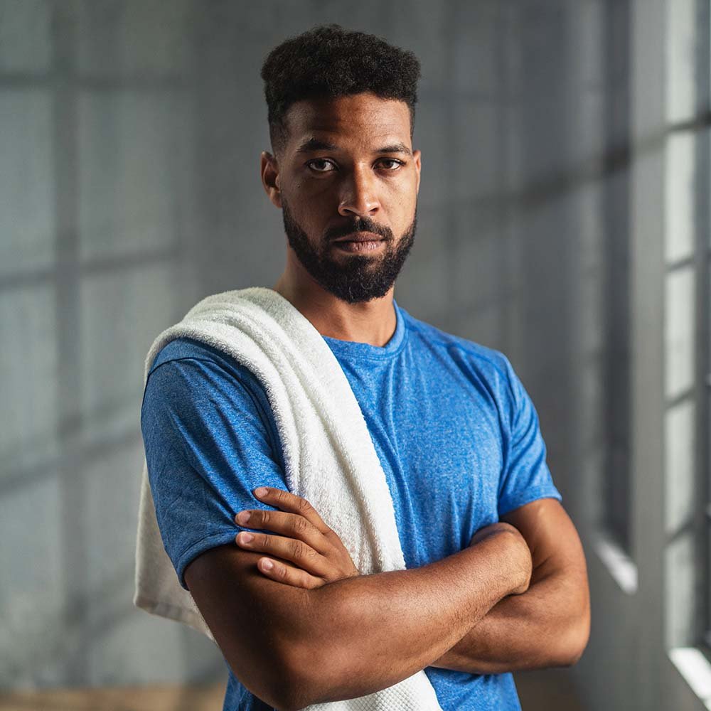 african-american-sportsman-standing-indoors-at-gym-P9AY9ZP.jpg